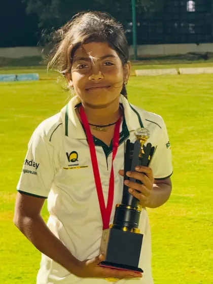 A young girl from our academy proudly holds her trophy.