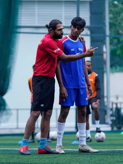 A coach provides real-time feedback during a training drill. This hands-on approach ensures that players understand and correct their technique, leading to faster skill development.