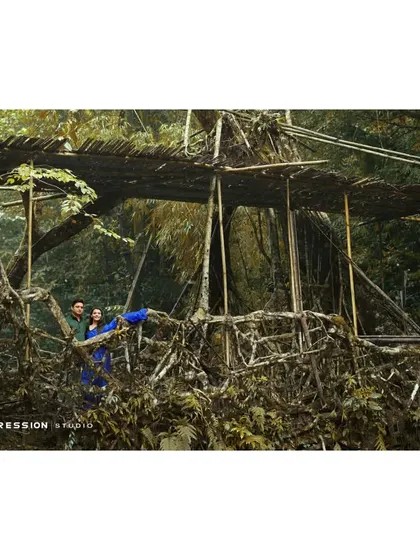 An adventurous shot on a living root bridge. This photo is for the couple that loves to explore, showcasing their journey together in a unique and breathtaking natural wonder.