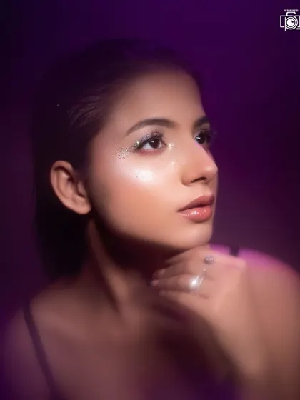 A purple light wash adds a touch of fantasy to this beauty shot. The model's upward gaze and the soft lighting create a hopeful and serene portrait.