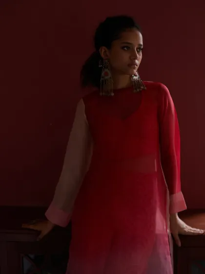 A moody and atmospheric shot for an ethnic wear brand. The play of shadow and deep red tones creates a rich, dramatic feel.