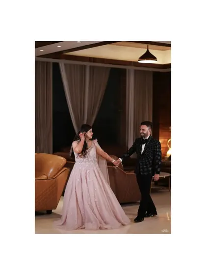 A full-length shot of the couple walking hand in hand, the bride's gown flowing beautifully. This captures the elegance of their engagement night.