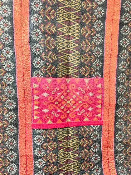 A collection of reversible memory quilts crafted from the sarees of a client's mother. Each side tells a different story, preserving the fabric's patterns and colors in a new, functional form.