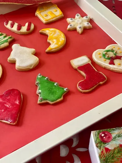 A closer look at the detailed icing work on our Christmas cookies. You can see the delicate piping on the Christmas tree, stocking, and crescent moon shapes, each finished with silver dragées.