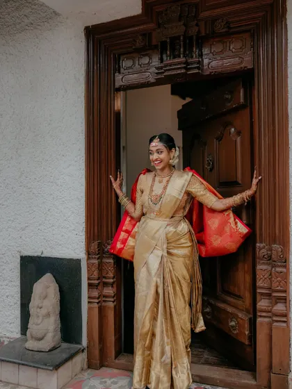 A joyful bride peeking out from behind a traditional wooden door. This playful and happy shot captures her excitement and personality perfectly.