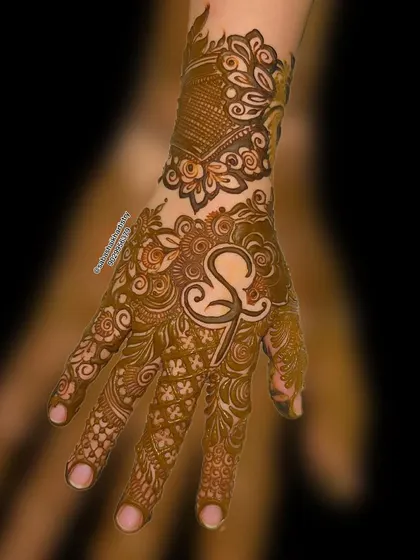 A modern and stylish design with a large 'S' initial as the centerpiece, surrounded by Arabic-style patterns.