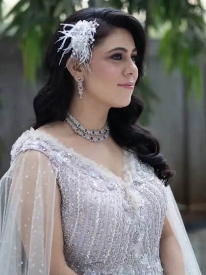 The complete look, showing how the wavy hair and cape-style gown create a dramatic and elegant effect. This is a perfect hairstyle for a modern reception or engagement party.