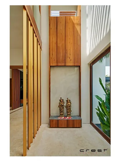 A double-height puja niche in the 'Framed House,' using verticality and natural light to create a serene, minimalist spiritual space.