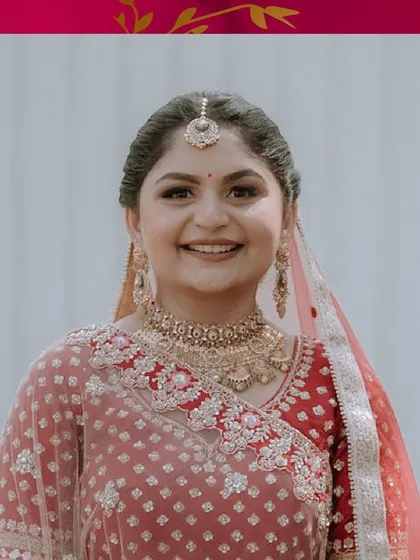 A happy, smiling portrait of the bride. Her natural, glowing makeup and traditional gold jewellery are perfect for her wedding day.