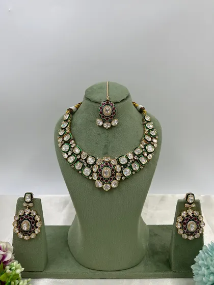 A pair of stunning oversized earrings with green and red Meenakari work, set with Moissanite stones. These are perfect as standalone statement pieces.
