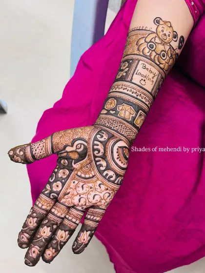 A lovely baby shower design with a 'Baby Loading' message and a cute teddy bear on the arm. The hand features a mix of traditional peacock and floral patterns.