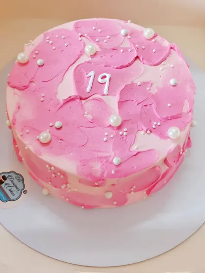 This mini cake, made for a 19th birthday, features a modern textured design in pink. I added delicate sugar pearls to give it an elegant finish.