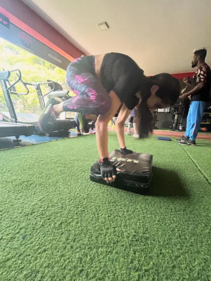 A client practices a crow pose on a soft block, an advanced drill for building balance, core strength, and wrist stability.