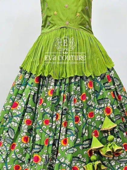 A green Kalamkari print lehenga with a matching green peplum top. The vibrant floral print is perfect for daytime events.