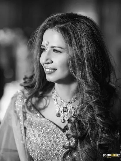 A timeless black and white portrait of the bride, showcasing her elegant jewelry and radiant smile during her engagement party.