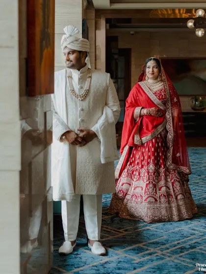 A classic wedding portrait in a hotel corridor, the couple's elegant stance and beautiful outfits creating a timeless image.