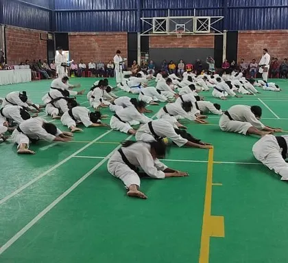 Students engaged in deep stretching exercises, an essential part of their preparation and assessment during the belt exam.