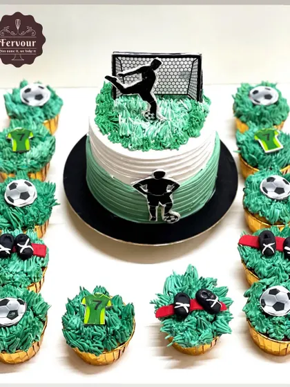 A football-themed cake complete with matching cupcakes. The cake and cupcakes are decorated with green frosting to look like a grassy field, with edible footballs and jerseys.