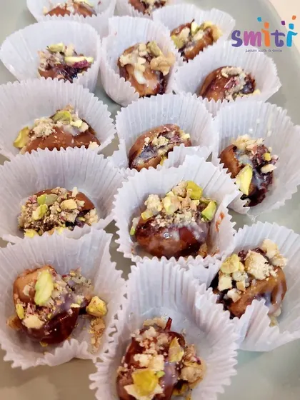 The finished date desserts, beautifully presented in paper cups and topped with crushed nuts. The children were proud to have created such a delicious and attractive treat.