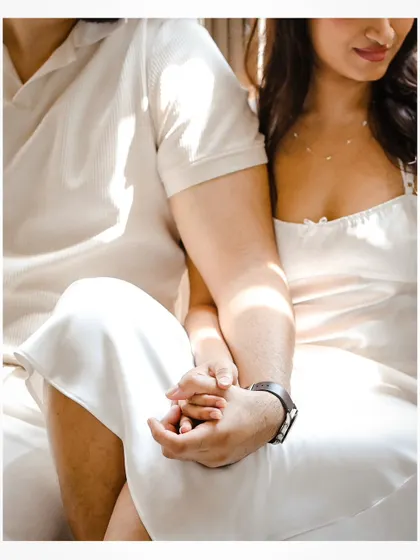 A close-up detail shot of the couple holding hands during their pre-wedding session.