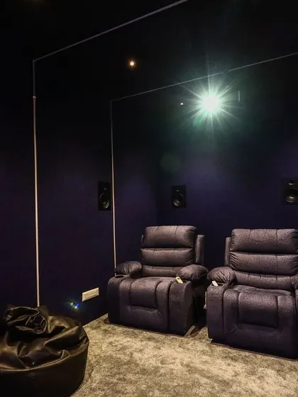 With the lights dimmed, the room becomes a dark, private screening space. The purple walls absorb light, preventing reflections and enhancing picture contrast.