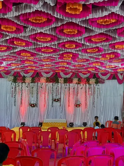 A full view of a Haldi event setup inside a pandal. The combination of the colorful ceiling, stage backdrop, and seating creates a complete festive look.