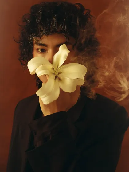 A conceptual portrait with smoke and a flower, creating a mysterious and dreamlike image.