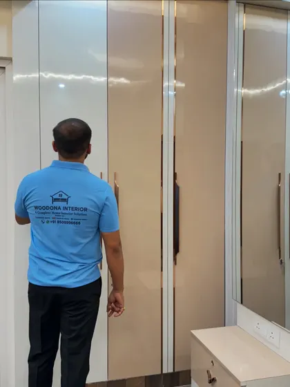 A look at an open-shutter wardrobe with a dual-tone laminate finish and elegant rose gold profile handles.