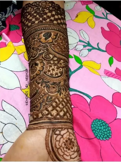 A single arm covered in a dense, intricate pattern. This view highlights the beautiful check-patterned cuff design on the upper forearm.