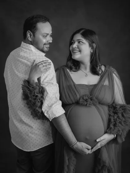 A black and white portrait of an expecting couple sharing a smile. This image captures the joy and partnership of the pregnancy journey.