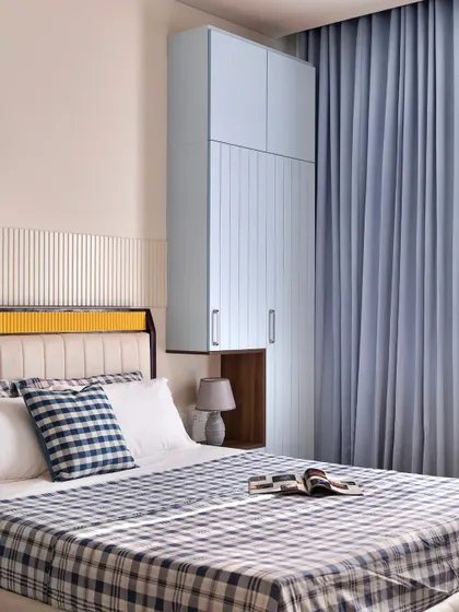 For the father's bedroom, I used a powder blue theme for a calming effect. The floating wardrobe includes a built-in nightstand, a smart solution for a compact space.