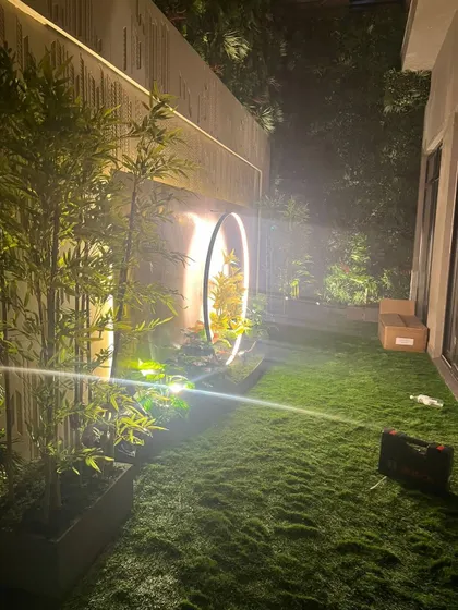 I design green spaces that feel magical, day or night. This residential garden project features my soft artificial turf, complemented by strategic lighting on the surrounding artificial plants and a modern circular sculpture.