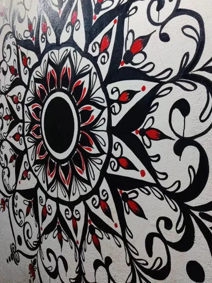 A close-up detail shot of another mandala project. You can see the clean lines and the contrast between the bold black ink and the small, vibrant red accents that make the design pop.