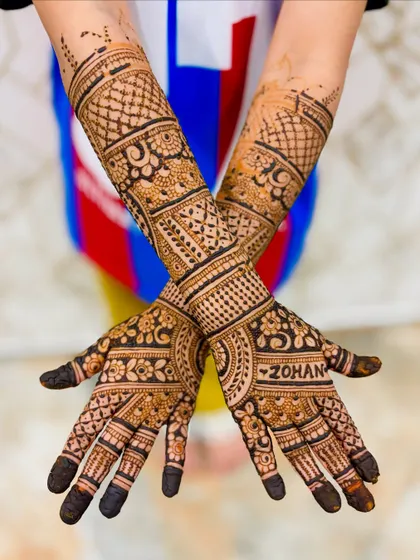 A crossed-hands view of the intricate mehendi for the 6-year-old client.