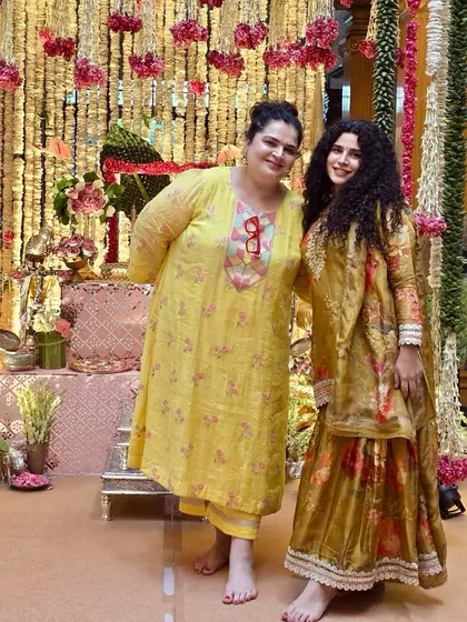 Two clients looking fresh and bright for the festivities. On the left, a custom yellow mul mul chanderi suit set, and on the right, a coordinated gold and floral gharara set.