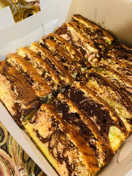 A box filled with freshly baked, super fluffy Ribbon Cake slices. This is one of my most popular tea cakes.