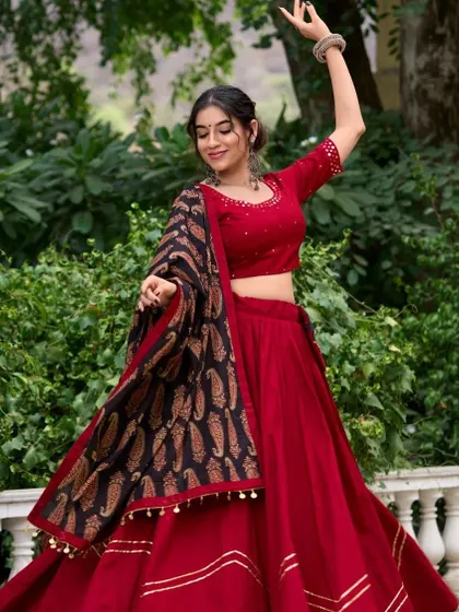 A classic red chaniya choli paired with a black and gold printed dupatta. This is a timeless look that's both elegant and festive.