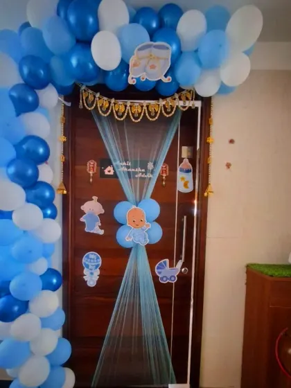 A 'Welcome Baby' decoration for the front door. I created a blue and white balloon arch and used blue netting with baby-themed cutouts to make the entrance special.