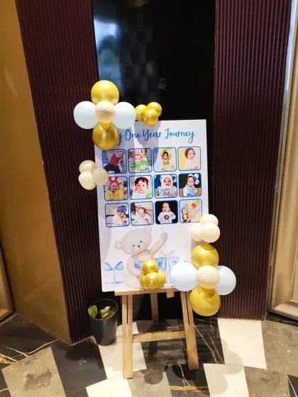 A 'One Year Journey' photo board for a first birthday. This is a great way to display memories from the baby's first year, framed with a simple balloon accent.