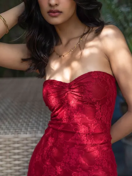 A close-up on a vibrant red lace top. The focus on the texture and color makes this a striking and desirable image for a fashion brand.