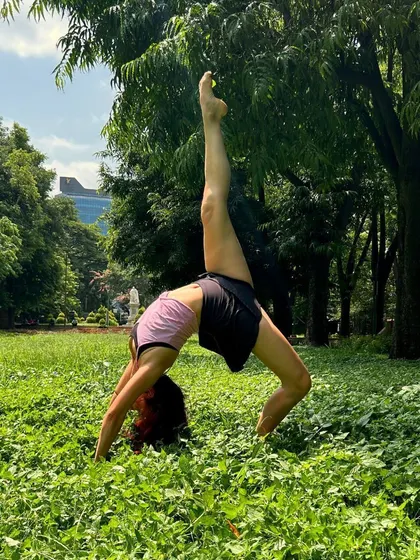 Dance isn't confined to the studio. Here, one of our contemporary dancers finds a moment of expressive freedom outdoors, showcasing incredible flexibility and balance.