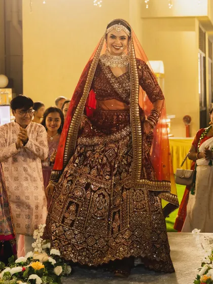 The bride's grand entrance. Her magnificent lehenga and radiant makeup ensure all eyes are on her as she walks down the aisle.