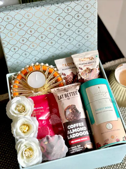 A beautiful blue Moroccan-themed Diwali box, filled with a decorated tea light, almond brittle, and dhoop sticks.