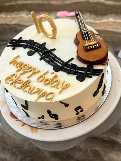 A cake for a little guitarist, featuring a handcrafted guitar and a cascade of musical notes.