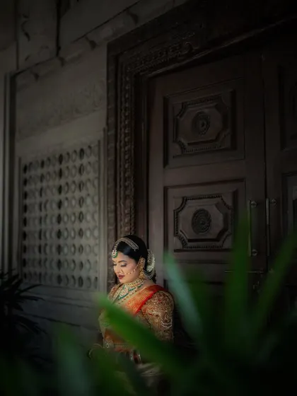 A quiet moment of the bride framed by greenery and an old doorway. The soft lighting and her contemplative pose create a very peaceful and beautiful portrait.