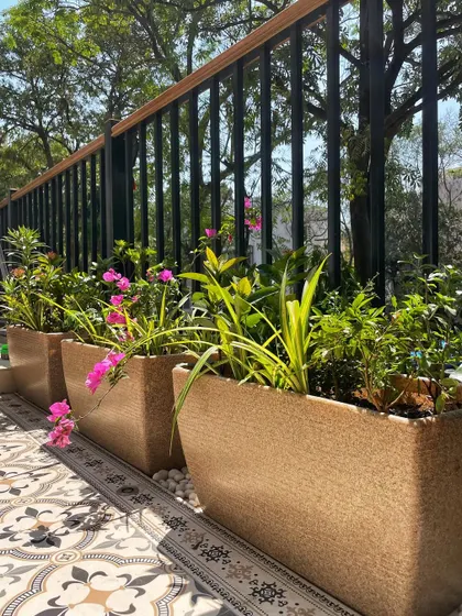 Even a small nook can become a beautiful green feature. Here, our textured planter boxes filled with Bougainvillea and other flowers brighten up a walkway with beautiful patterned tiles.