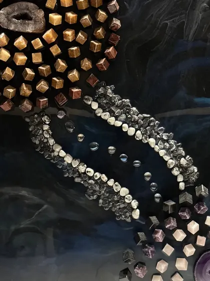 This is a detail shot of a massive 10 by 6 feet conceptual wall art piece I created. It's made with over 40 kgs of resin and features natural stones arranged to represent the sun and planets, linking astrology and art.