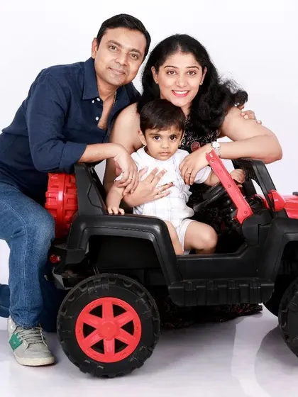 A fun family portrait featuring mom, dad, and their little one in a toy jeep. This playful setup adds a unique and memorable twist to a classic family photo.