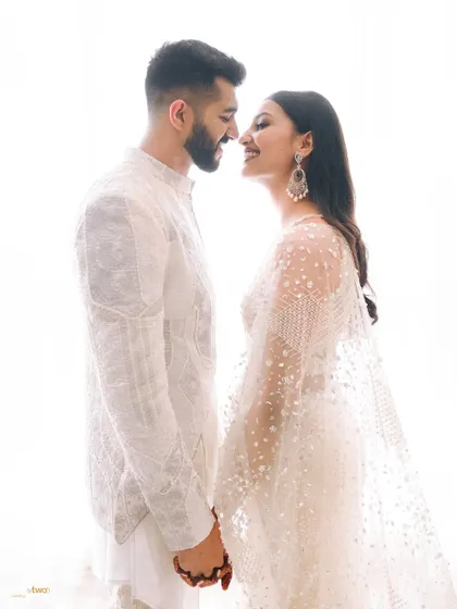 A classic, happy portrait of a couple, their faces close, smiling at each other. The bright, high-key lighting gives the image a dreamy, ethereal feel.