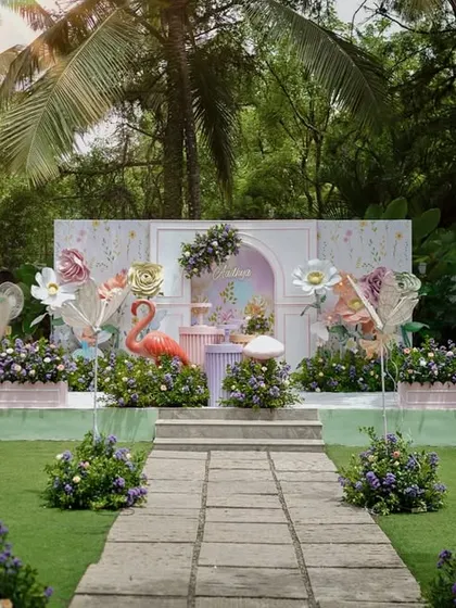 A full view of Aadhya's magical flower garden party. The setup includes a custom backdrop, oversized paper flowers, whimsical fairy wing props, and lush floral arrangements to create an enchanted atmosphere.